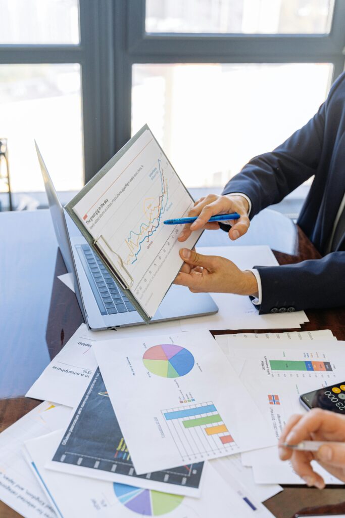 Man showing statistics on a clipboard on top of papers of charts