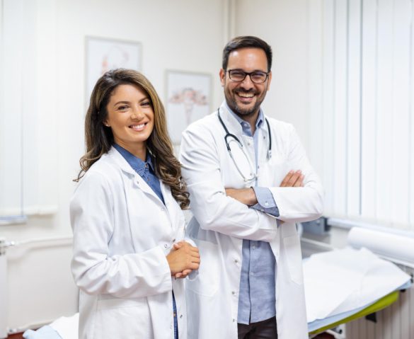 Happy male and female doctors smiling at the camera