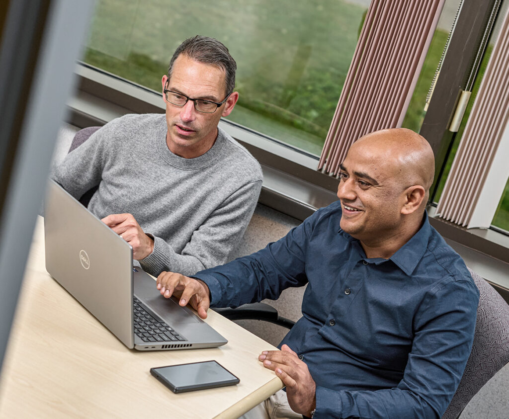 Two IT professionals working on a computer